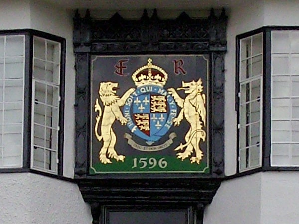 Decorative royal crest on building facade from 1596