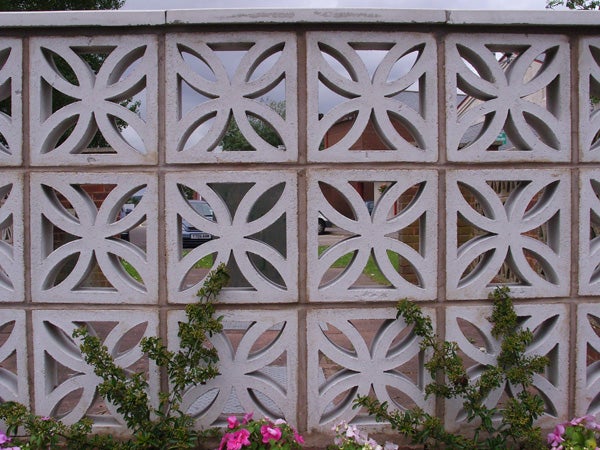 Decorative concrete wall with geometric flower patterns.
