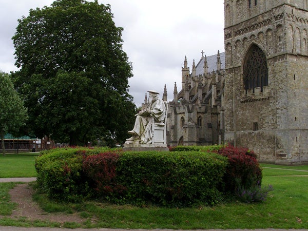 Statue and medieval church captured in daylight.