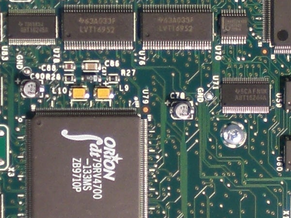 Close-up of a green circuit board with microchips and components.