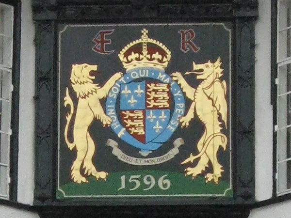 Coat of arms with lions and a crown painted on a wall.