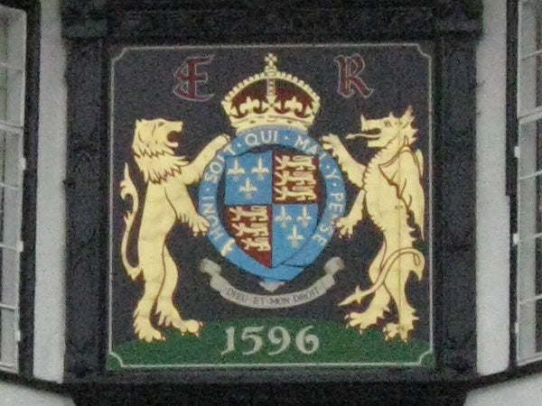 Coat of arms on a plaque with lion supporters and crown.