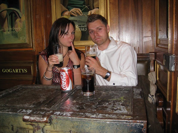 Couple sitting at a pub table with drinks.