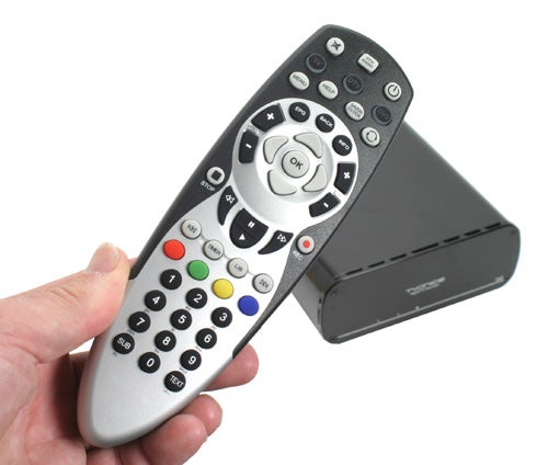Hand holding Tvonics DVR-250 Freeview box and remote control.
