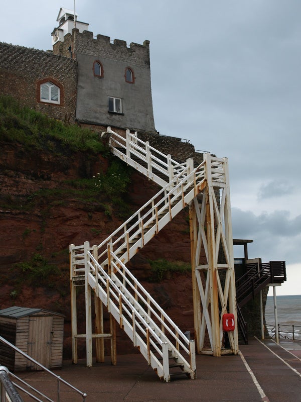 White staircase leading to a historical tower on a cliffside