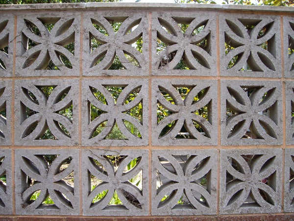 Decorative concrete block wall with geometric pattern.