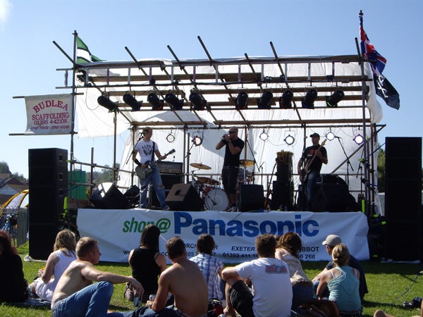 Band performing on stage at an outdoor event.