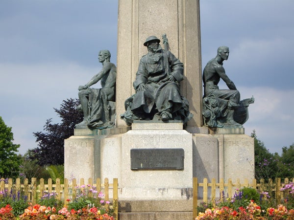 War memorial statues surrounded by flowers.