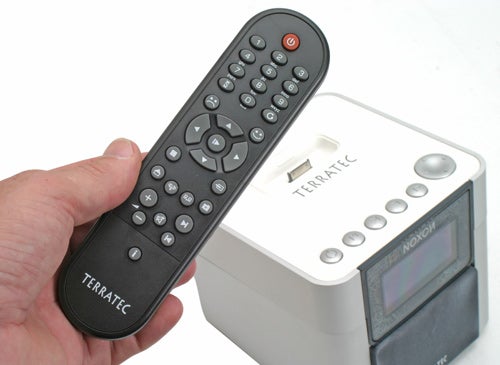 Hand holding Terratec Noxon 2 remote with the radio in the background.