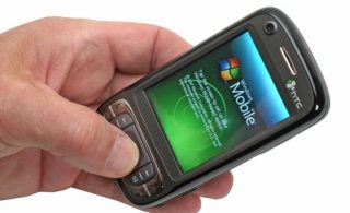 Hand holding an HTC P4550 Kaiser Smartphone displaying Windows Mobile.