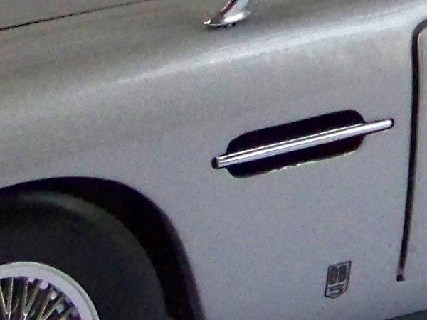 Close-up of car door and handle with blurred background.