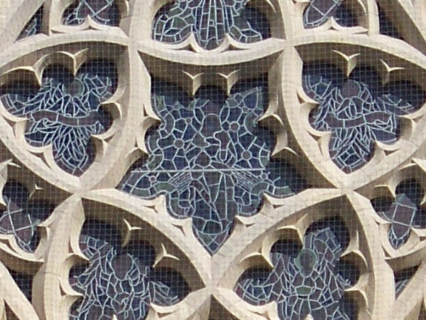 Close-up of gothic stone window tracery and stained glass.