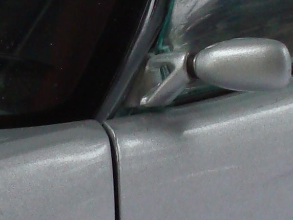 Close-up of a car's side mirror and door.