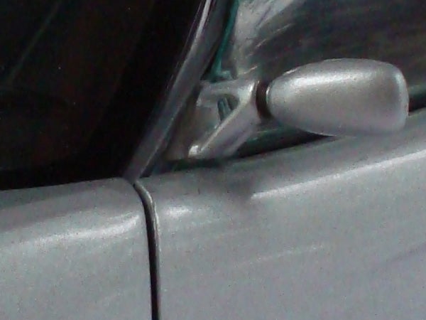 Close-up of a car's side mirror and door junction.