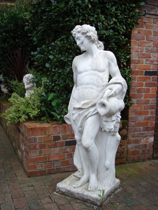 White marble statue in a brick-lined garden setting