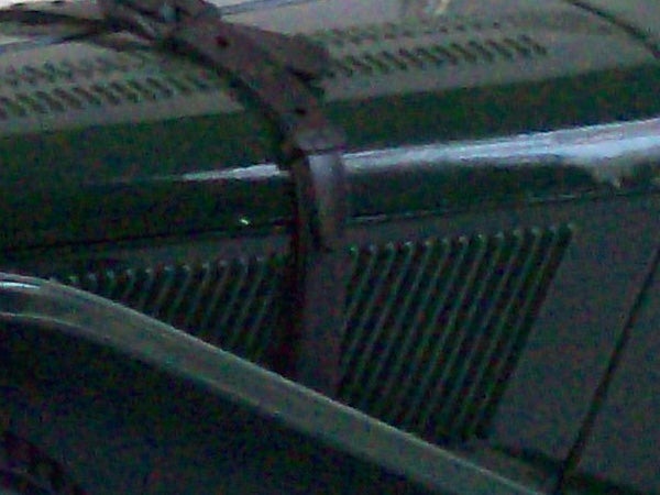 Low-resolution photo of a car grille taken at night.