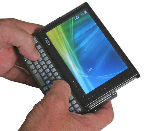 Hand holding OQO Model 02 Ultra Mobile PC with screen visible.