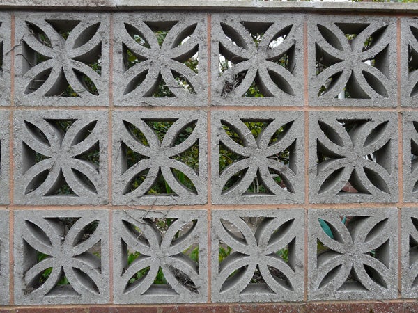 Decorative concrete block wall with a floral pattern.