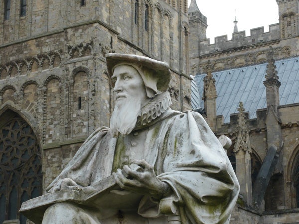 Statue of a historic figure in front of a cathedral