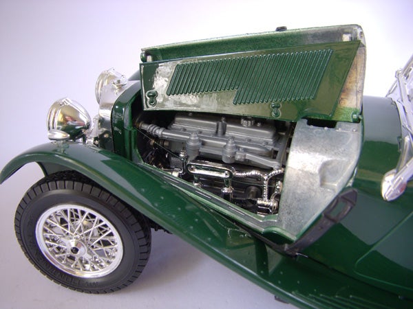 Green vintage toy car with detailed engine model.