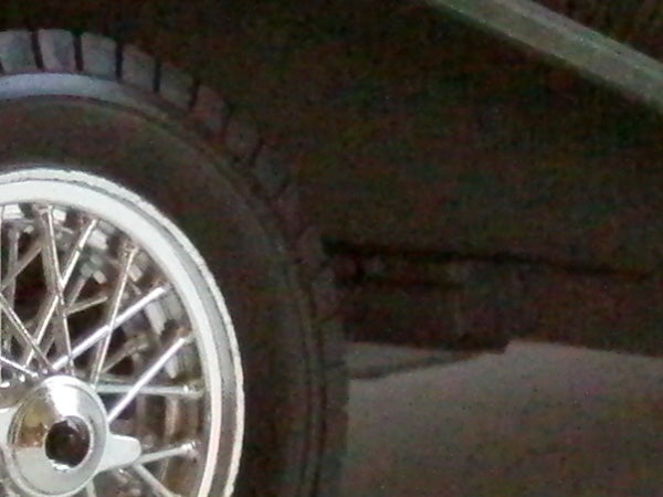 Low-light photo showing a blurry car wheel.