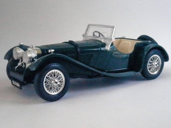 Model of a vintage green roadster car with white tires