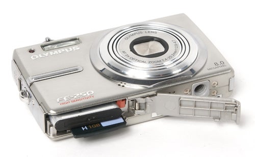 Olympus FE-250 digital camera with open memory card slot.