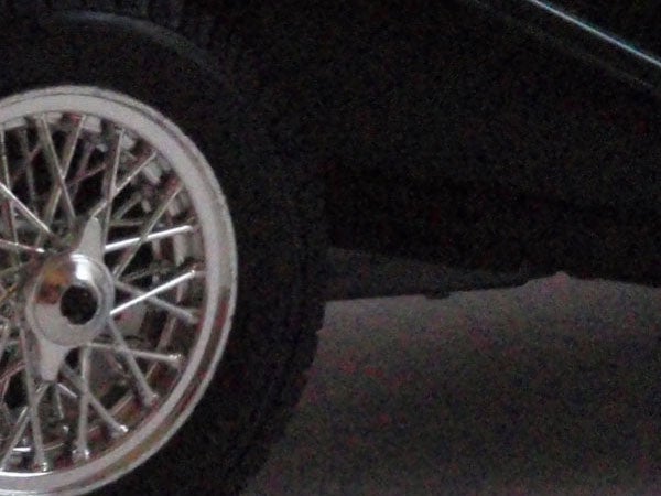 Car wheel with intricate spoke design.