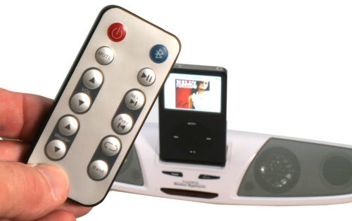 Hand holding remote with TwinMOS Speaker and iPod in background