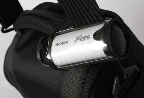 Sony GPS location recorder attached to a black backpack strap.