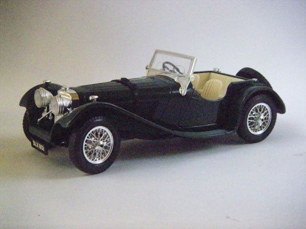 Toy model of a vintage black car with white interior.