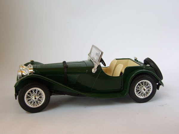 Green vintage model car on a white background.