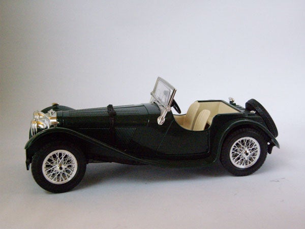 Vintage green model car displayed on a gray background.