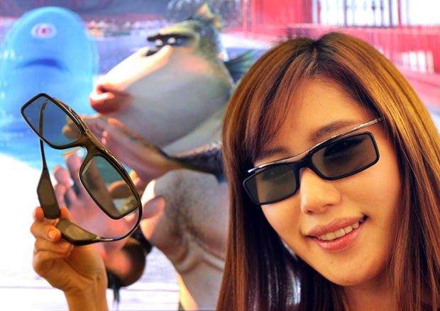 Woman holding 3D glasses with animated characters in background.