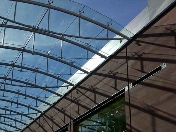 Glass canopy and building exterior with shadow patterns.