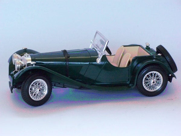 Model of a classic green roadster car with white tires.