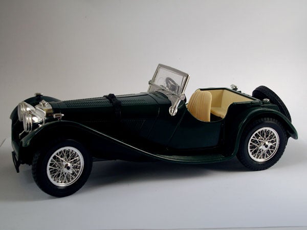 Vintage green model car displayed on a white background