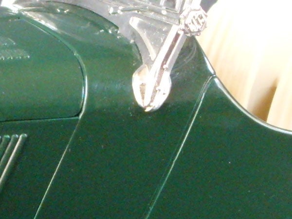 Close-up of a vintage green car model with chrome details.