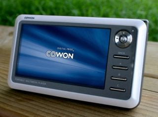 Cowon A2 portable multimedia player on wooden surface.
