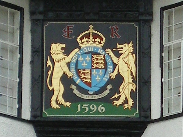 Coat of arms with lions and a crown, displayed on a building.