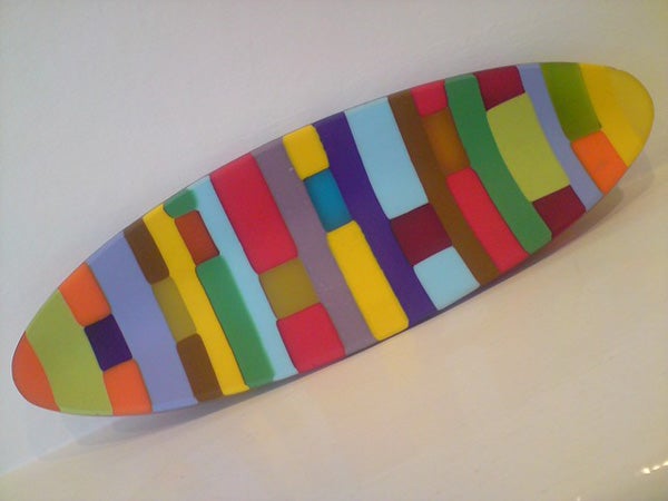 Colorful abstract patterned surfboard on white background