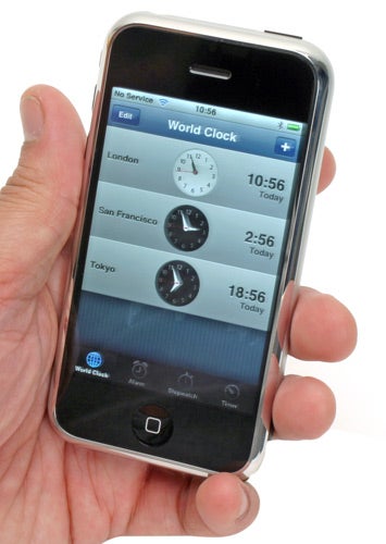 Hand holding an Apple iPhone displaying the World Clock app.