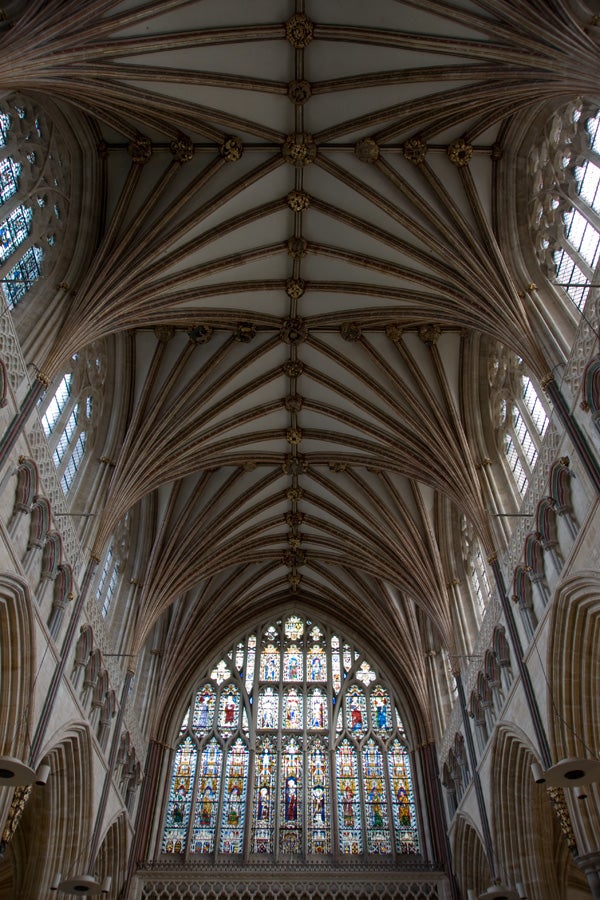 Gothic cathedral interior with vaulted ceiling and stained glass.