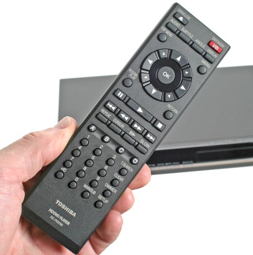 Hand holding Toshiba HD-EP30 DVD Player remote control.
