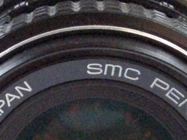 Close-up of camera lens with brand inscription
