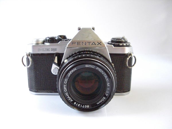 Vintage Pentax film camera on a white background.