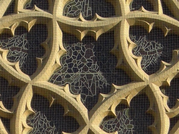 Intricate golden pattern on dark backgroundIntricate patterned metalwork with cobweb details.