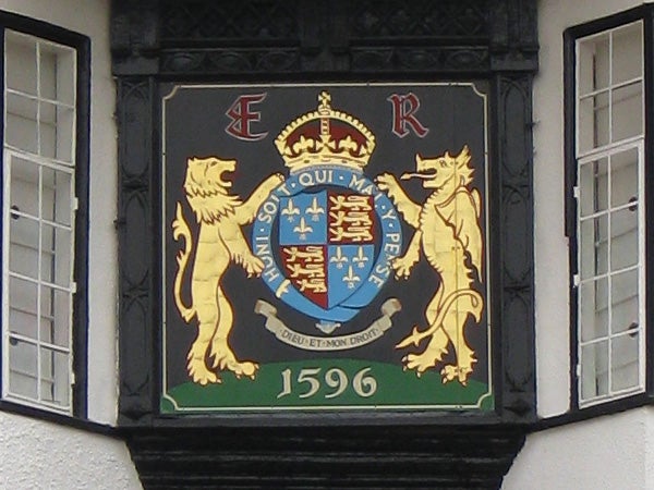 Coat of arms with lions and a date plaque from 1596.Coat of arms plaque on building exterior from 1596.
