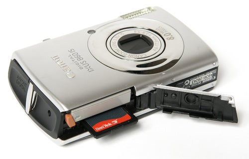 Canon IXUS 860 IS camera with open battery compartment.