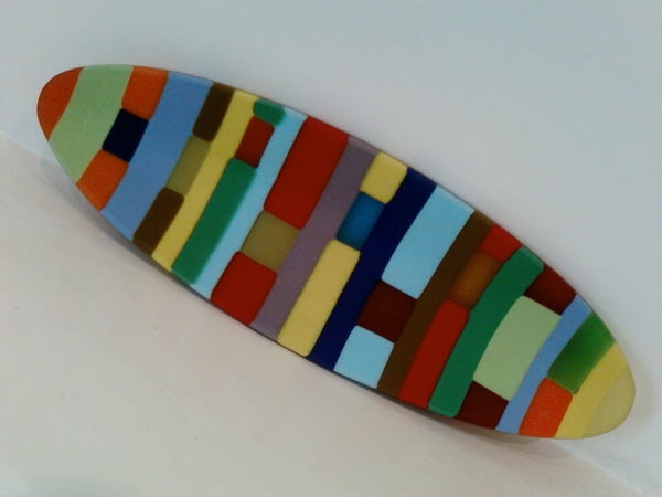 Colorful striped surfboard on a white background.Colorful abstract pattern on an elliptical shape